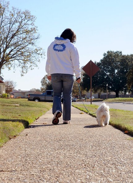 Maria Guiao, wife of Master Sgt. Arnold Guiao, 2nd Medical Support Squadron, walks her dog Sami through base housing on Barksdale Air Force Base, La., Nov. 29. Though Louisiana weather is famous for being hot, the oncoming winter season has brought cooler weather to the area, making it a 'nicer walk around base,' said Maria Guiao. (U.S. Air Force photo/Senior Airman Amber Ashcraft)(RELEASED)