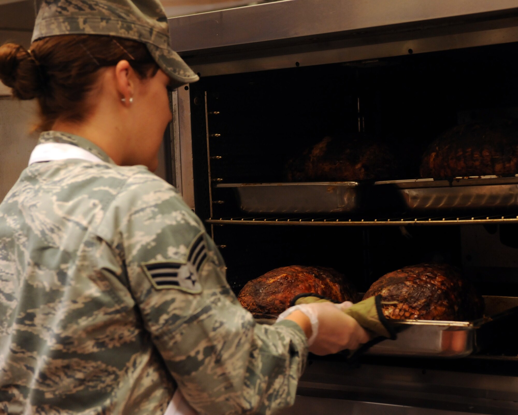 Senior Airman Kristie Adkins, 355th Force Support Squadron, takes a pan of turkeys out of the oven in the Desert Dining Inn on Davis-Monthan Air Force Base, Ariz. Nov. 24, 2011. The Desert Dining Inn offered turkey, ham, and roast to its patrons. (U.S. Air Force Airman 1st Class Timothy D. Moore/Released)