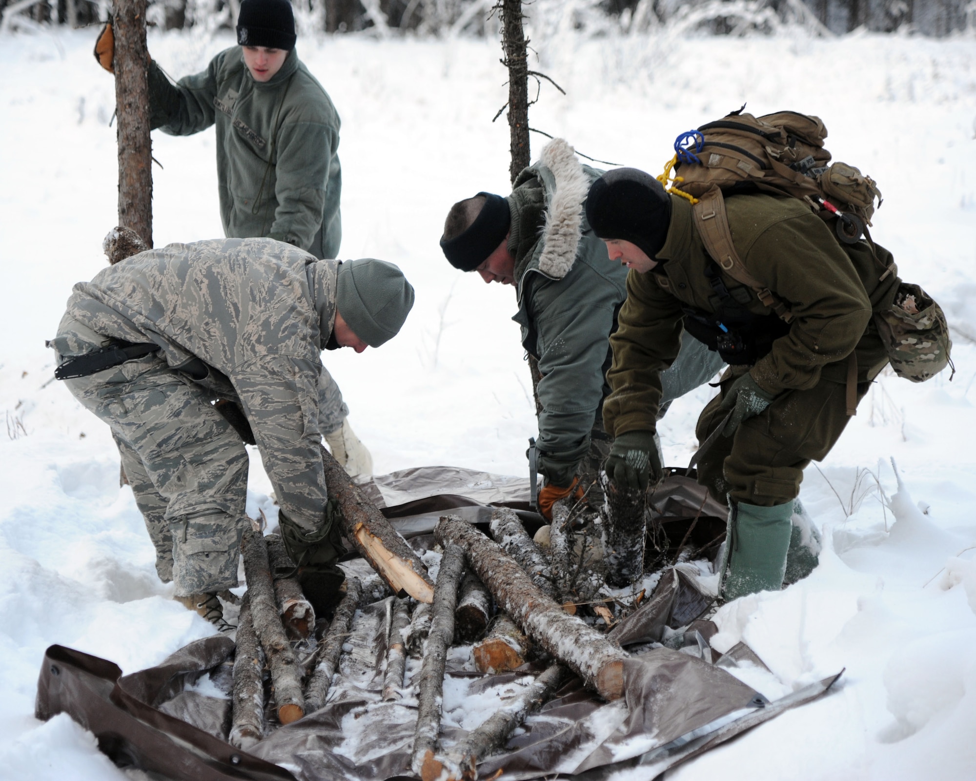 A Survival Evasion Resistance Escape specialist aids Arctic Survival School students with the contrast elements of a rescue and recovery signal Nov. 9, 2011, Eielson Air Force Base, Alaska. (U.S. Air Force photo/Willard Grande II)