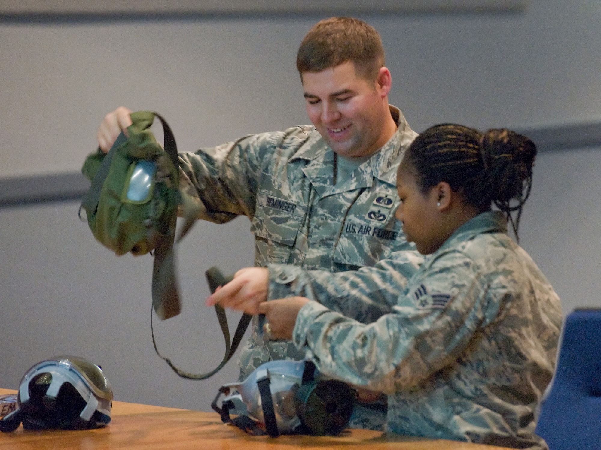 Staff Sgt. Bradley Iseminger, an emergency management instructor with the 436th Civil Engineer Squadron, instructs Senior Airman Natalie East, services apprentice with the 436th Force Support Squadron, on the proper inspection and wear of the MCU-2/P mask at the base theater Nov. 28, 2011, Dover Air Force Base, Del. Team Dover members received final Operational Readiness Inspection training as the 436th and 512th Airlift Wings prepare for an upcoming ORI. (U.S. Air Force photo/Roland Balik)