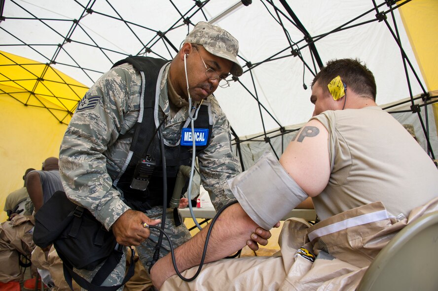 Air National Guard Staff Sgt. James Gill, left, 116th Medical Group (MDG) medical technician, Robins Air Force Base, Ga., checks the vital signs of a first responder in the recovery tent during Operation Sunrise Rescue at Camp Blanding Joint Training Center, Fla., Nov. 18, 2011.  The 116th MDG received a perfect score in the joint force exercise to test their skills as a Chemical, Biological, Radiological, Nuclear, and High Yield Explosive Enhanced Response Force Package.  (National Guard photo by Master Sgt. Roger Parsons/Released)