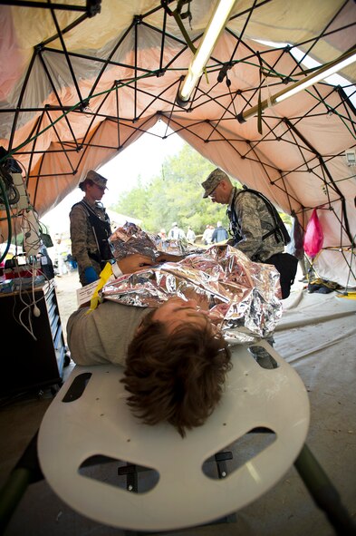 Air National Guard Col. Louis Perino, right, 116th Medical Group (MDG) chief of aerospace medicine, Robins Air Force Base, Ga., treats a simulated injured patient in the critical care tent while 2nd Lt. Sarah Kathe, 116th MDG nurse,  looks on during Operation Sunrise Rescue at Camp Blanding Joint Training Center, Fla., Nov. 18, 2011.  The 116th MDG received a perfect score in the joint force exercise to test their skills as a Chemical, Biological, Radiological, Nuclear, and High Yield Explosive Enhanced Response Force Package.  (National Guard photo by Master Sgt. Roger Parsons/Released)
