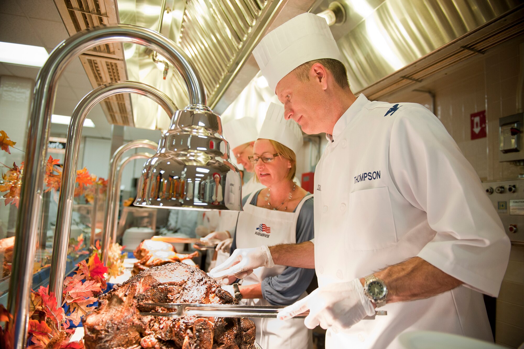 U.S. Air Force Col. Billy Thompson, 23rd Wing commander, and his wife, Julie, cut slices of roast beef during Thanksgiving at the Georgia Pines Dining Facility, Moody Air Force Base, Ga., Nov. 24, 2011. Thompson and many other Moody leaders helped serve the customary Thanksgiving meal at the DFAC for Airmen and their families. (U.S. Air Force photo by Staff Sgt. Jamal D. Sutter/Released)