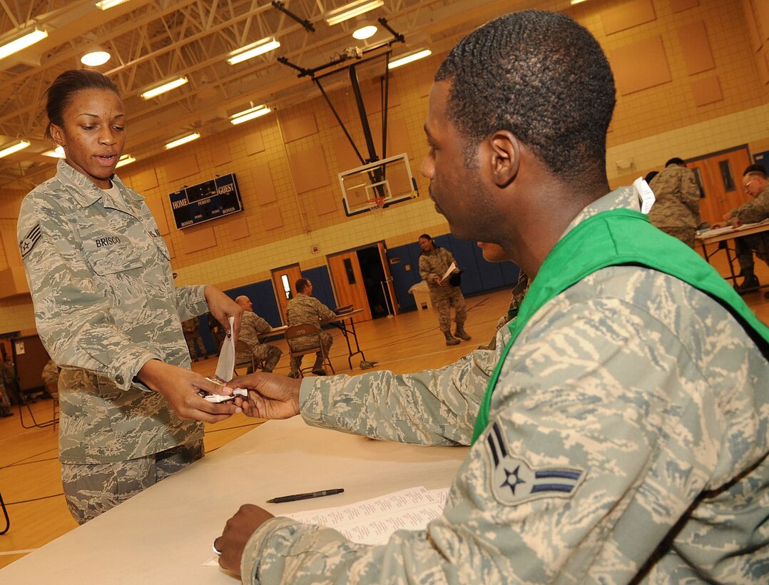 U.S. Air Force Staff Sgt. Alexisa Brisco, 633rd Surgical Operations Squadron medical technician, receives simulated Tamiflu from Airman 1st Class Donald Akins, 633rd Medical Support Squadron pharmacy technician, during a mass prophylaxis exercise at Langley Air Force Base, Va., Nov. 17, 2011. Medical Group team members processed 86 “symptomatic personnel” at an average of seven to nine minutes per patient. (U.S. Air Force photo by Airman 1st Class Racheal Watson/Released)