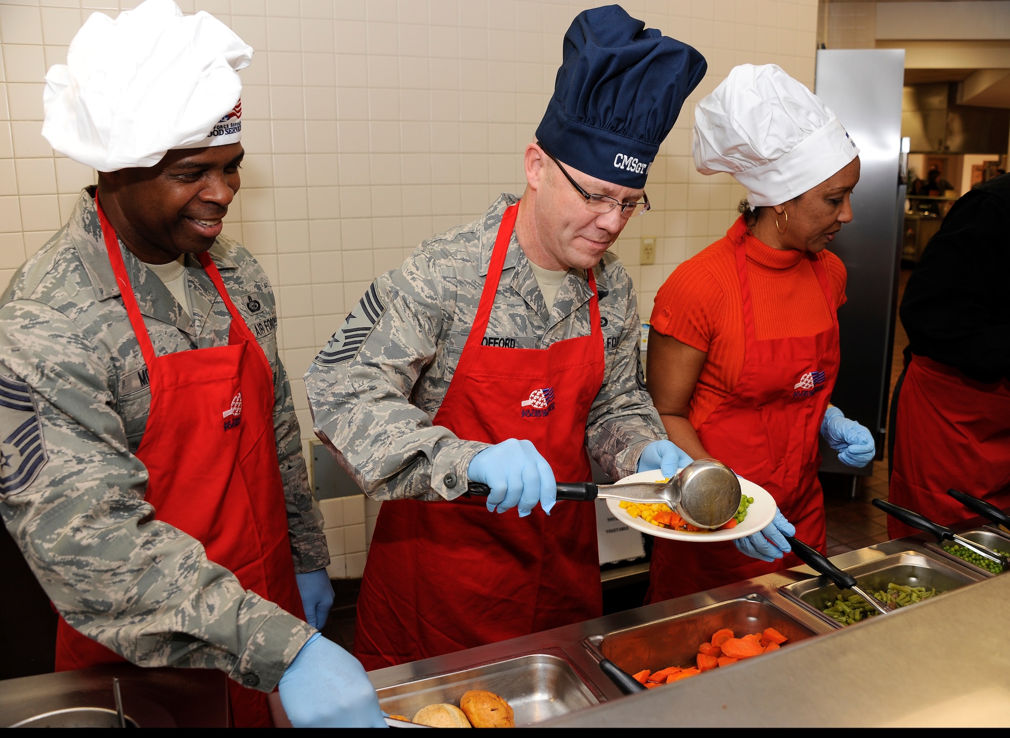 Chief Master Sgt. Charles McLaurin, 87th Mission Support Group superintendent (left) and Chief Master Sgt. Warren Wofford, 87th Air Base Wing command chief, prepare a plate of food for a servicemember during a Thanksgiving lunch Nov. 24 at the Halvorsen Hall dining facility. This event is an opportunity for senior leadership to show appreciation to servicemembers for all the work they do throughout the year. (U.S. Air Force photo by Airman 1st Class Bryan Swink/Released)