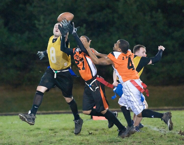 436th Aerial Port Squadron and 436th Medical Group members lunge for a tipped pass during a playoff match Nov. 28, 2011, at Dover Air Force Base, Del. The 436th MDG toppled the Port Dawgs 18-13, bringing them one step closer to the championship match. (U.S. Air Force photo by Airman 1st Class Samuel Taylor)
