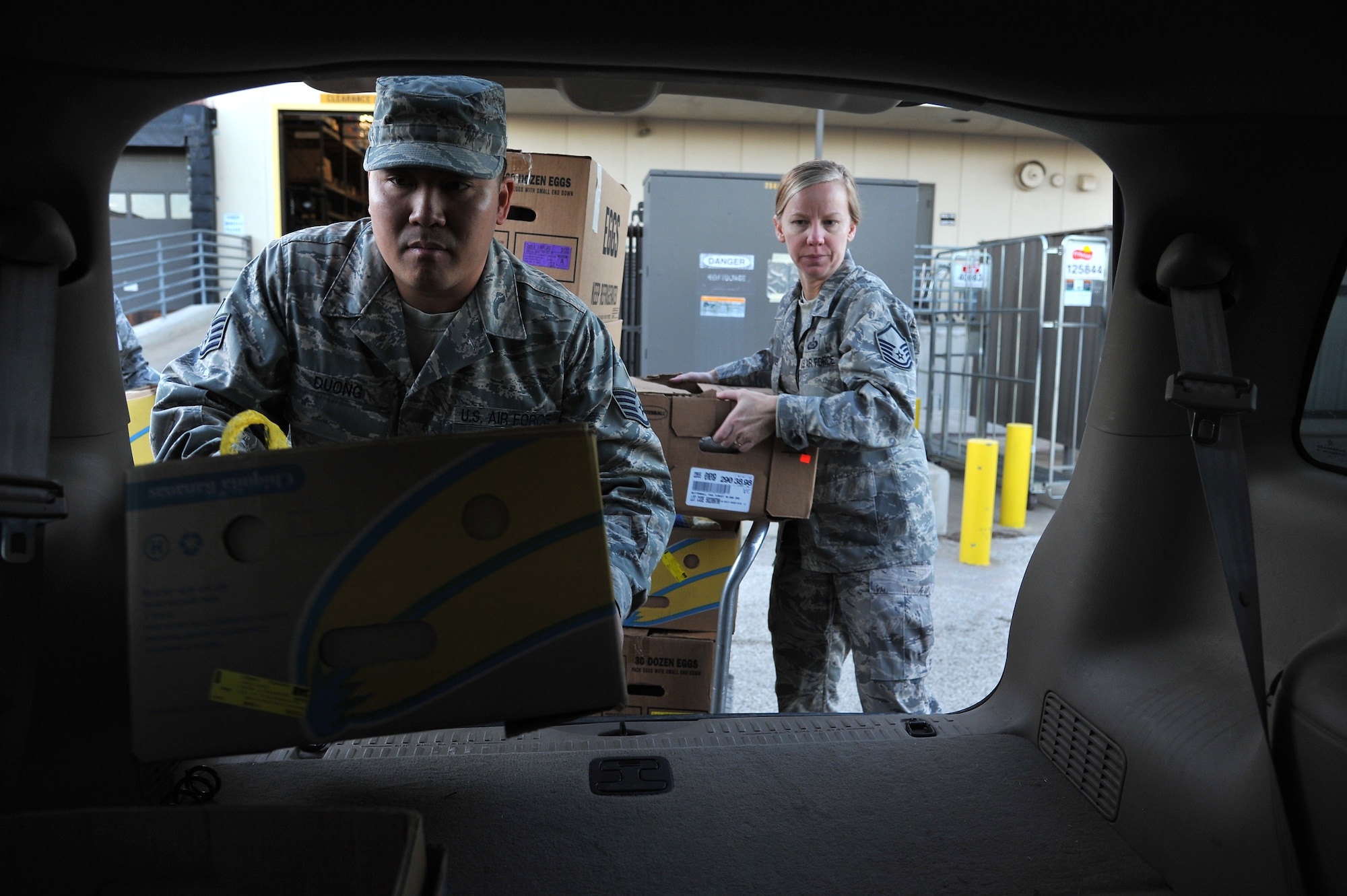 GOODFELLOW AIR FORCE BASE, Texas -- Staff Sgt. Tong Duong, 17th Training Wing Public Affairs, and Master Sgt. Ina Peeples, 315th Training Squadron, place boxes of assorted food into the back of a vehicle Nov. 22. Several members of every squadron from Team Goodfellow came together to help and pack food for Operation Warmheart. (U.S Air Force photo/Airman 1st Class Michael Smith)