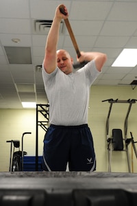 U.S. Air Force Staff Sgt. Eric Thomsen, 1st Maintenance Squadron lead physical training leader, demonstrates the correct way to execute an exercise during a PT session at Langley Air Force Base, Va., Nov. 22, 2011. Airmen participate twice a week in circuits that are designed to be intense, but informative, teaching them challenging and fun ways to work out to improve their fitness. (U.S. Air Force photo by Airman 1st Class Kayla Newman/Released)