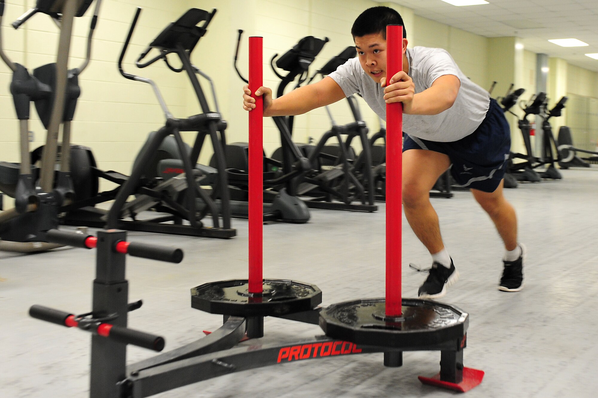 U.S. Air Force Airman 1st Class Jackson Nguyen, 1st Maintenance Squadron low observable aircraft structural maintenance apprentice, performs sled pushes during a physical training session at Langley Air Force Base, Va., Nov. 22, 2011. The 1st MXS PT sessions include test fundamentals and more inventive activities, such as sled pushes and parachute sprints.  (U.S. Air Force photo by Airman 1st Class Kayla Newman/Released)