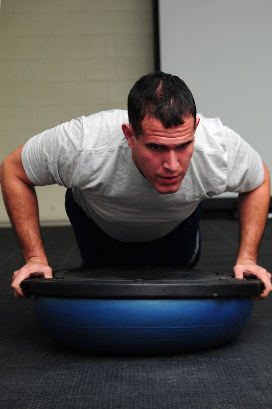 U.S. Air Force Airman 1st Class Vidal Rivera III, 1st Maintenance Squadron low observable aircraft structural maintenance apprentice, executes a specialized push-up during a physical training session at Langley Air Force Base, Va., Nov. 22, 2011.  An intense physical training regimen was developed for the 1st MXS, designed to transform mundane self-paced exercise into explosive, multi-faceted group workouts. (U.S. Air Force photo by Airman 1st Class Kayla Newman/Released)