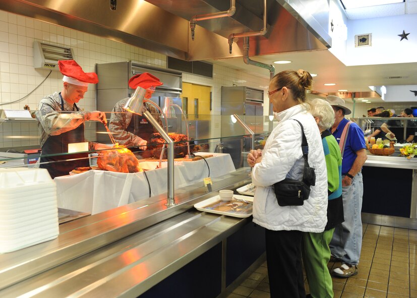 First sergeants and commanders serve turkey during the Thanksgiving feast at the Longhorn Dining Facility Nov. 24, 2011, at Dyess Air Force Base, Texas. First Sergeants and commanders helped serve food to airmen, retirees and their families. (U.S. Air Force photo by Airman 1st Class Cierra Bullock/Released)