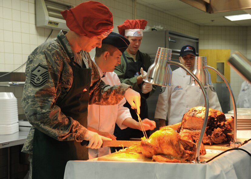 Master Sgt. Christopher Krieger, 7th Medical Group, slices turkey for the Thanksgiving feast at the Longhorn Dining facility Nov. 24, 2011, at Dyess Air Force Base, Texas. First sergeants and commanders helped serve food to airmen, retirees and their families. (U.S. Air Force photo by Airman 1st Class Cierra Bullock/Released)