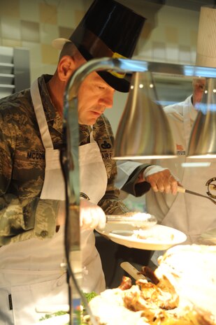 Colonel Richard McComb serves Thanksgiving dinner to Airmen and retirees at the Joint Base Charleston Dining Facility at JB Charleston - Air Base  Nov. 24. McComb, along with other unit commanders, chiefs and their families, took time out of their own Thanksgiving festivities to serve their fellow Airmen and retirees. McComb is the Joint Base Charleston commander. (U.S. Air Force photo/Airman 1st Class Ashlee Galloway)