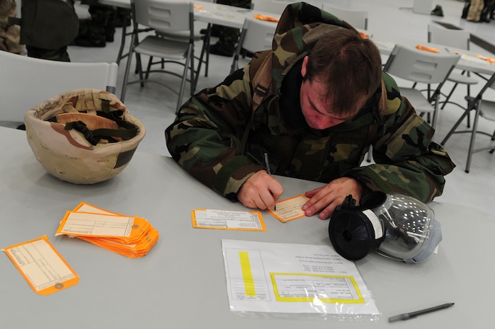Staff Sgt. Richard Barie fills out a Gas Mask inspection tag during the Ability To Survive and Operate Rodeo at Nose Dock One at Joint Base Charleston - Air Base Nov. 28.   The rodeo was held to help prepare more than 700 Airmen for the upcoming JB Charleston Operational Readiness Inspection. The rodeo included  Self Aid Buddy Care, weapons familiarization, Unidentified Explosive Objects training and donning chemical protection gear.  Barie is from the 628th Logistics Readiness Squadron.  (U.S. Air Force photo/ Staff Sgt. Nicole Mickle)  