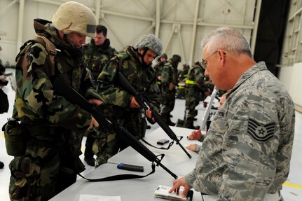 Technical Sgt. Isaac Jones reviews weapons familiarization with Airmen during the Ability To Survive and Operate Rodeo at Nose Dock One at Joint Base Charleston - Air Base Nov. 28. The rodeo was held to help prepare more than 700 Airmen for the upcoming JB Charleston Operational Readiness Inspection. The rodeo included  Self Aid Buddy Care, weapons familiarization, Unidentified Explosive Objects training and donning chemical protection gear. Jones is from the 628th Security Forces Squadron.  (U.S. Air Force photo/ Staff Sgt. Nicole Mickle)  