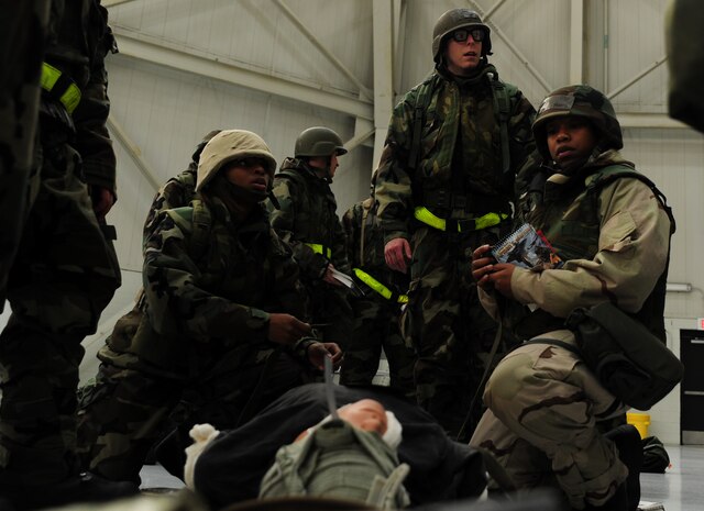 Mock deployers perform Self Aid Buddy Care on a simulated victim during the Ability To Survive and Operate Rodeo at Nose Dock One at Joint Base Charleston - Air Base Nov. 28.  The rodeo was held to help prepare more than 700 Airmen for the upcoming JB Charleston Operational Readiness Inspection. The rodeo included seven separate stations which tested Airmen on Self Aid Buddy Care, weapons familiarization, Unidentified Explosive Objects training and donning chemical protection gear. (U.S. Air Force photo/ Staff Sgt. Nicole Mickle)   