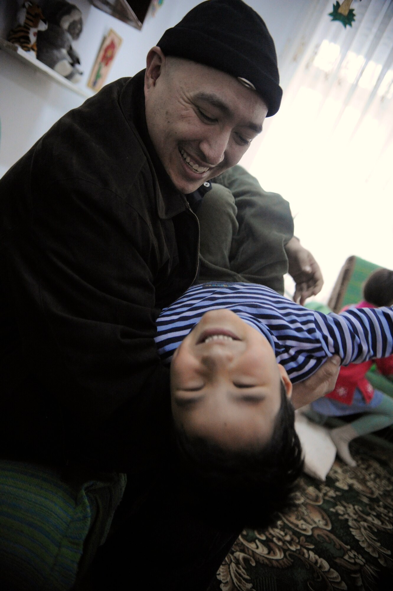 Tech. Sgt. Gerald Borchert plays with a child at the Belovodosky Orphanage during a Manas Area Benefit Outreach Society visit Nov. 28, 2011. MABOS members delivered clothing and toys to the children and spent time playing with them. Borchert is deployed to the Transit Center at Manas, Kyrgyzstan, as the 376th Expeditionary Logistics Readiness Squadron asset management section chief from Yokota Air Base, Japan. (U.S. Air Force photo/Tech. Sgt. Tammie Moore)