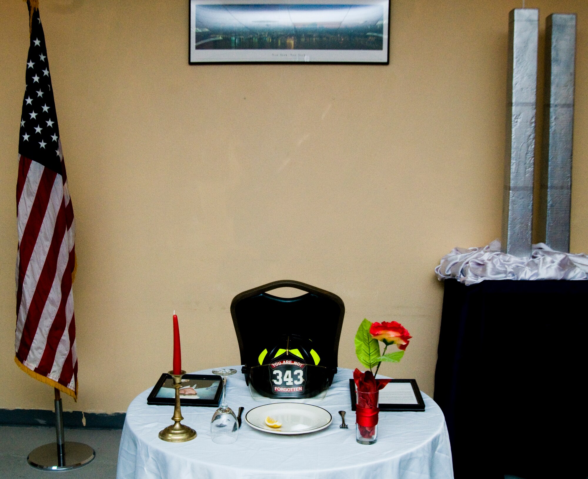 A table at the front of the Twin Towers room in the Manhattan Dining Facility at an undisclosed location in Southwest Asia commemorates the life of Peter J. Ganci Jr., Chief of the New York City Fire Department during the attacks of Sept. 11, 2001, and the other 342 first responders that died following the attacks on the World Trade Center. (U.S. Air Force photo/Senior Airman Eric Summers Jr.)