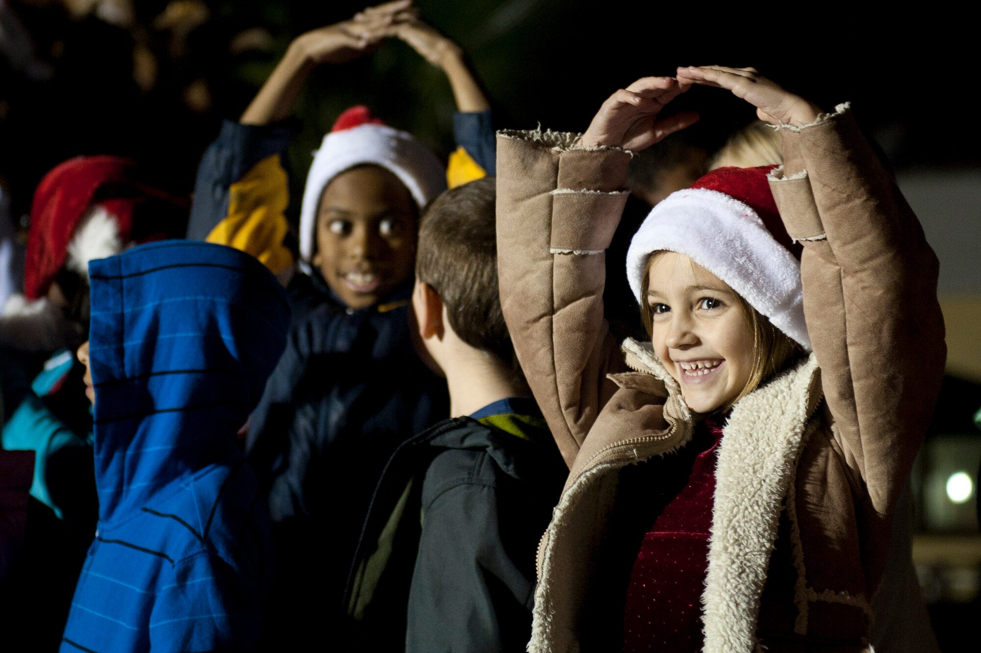 The Incirlik Elementary School choir performs outside the Club Complex during the base tree lighting ceremony Nov. 28, 2011, at Incirlik Air Base, Turkey. Col. Chris Craige, 39th Air Base Wing commander, and his children flipped the switch to light the holiday tree. (U.S. Air Force photo by Senior Airman Anthony Sanchelli/Released)