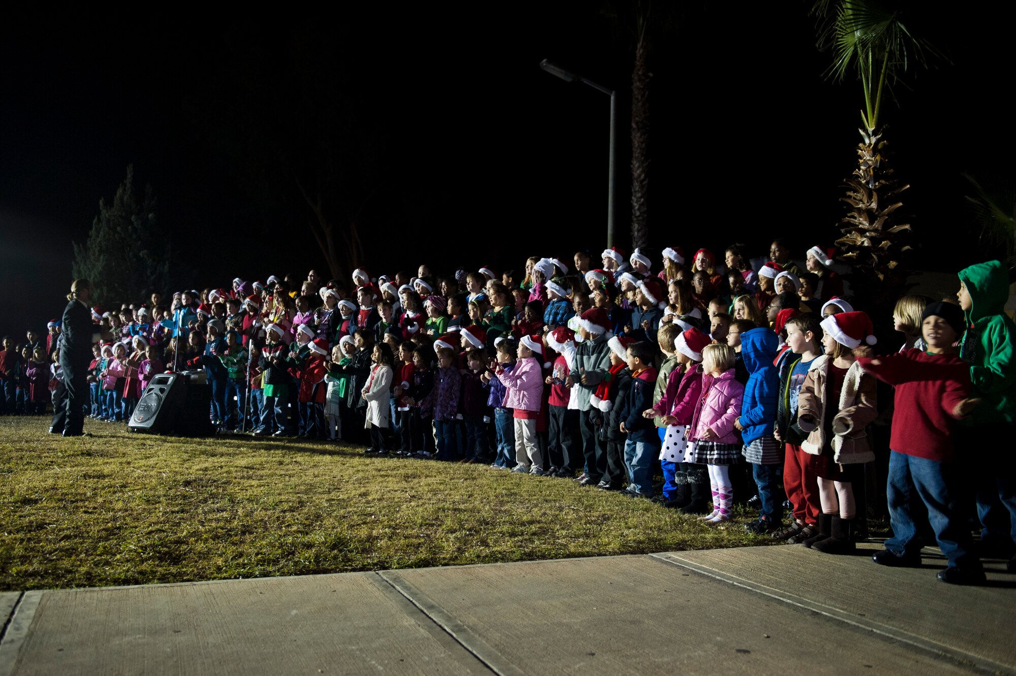 The Incirlik Elementary School choir performs outside the Club Complex during the base tree lighting ceremony Nov. 28, 2011, at Incirlik Air Base, Turkey. Col. Chris Craige, 39th Air Base Wing commander, and his children flipped the switch to light the holiday tree. (U.S. Air Force photo by Senior Airman Anthony Sanchelli/Released)