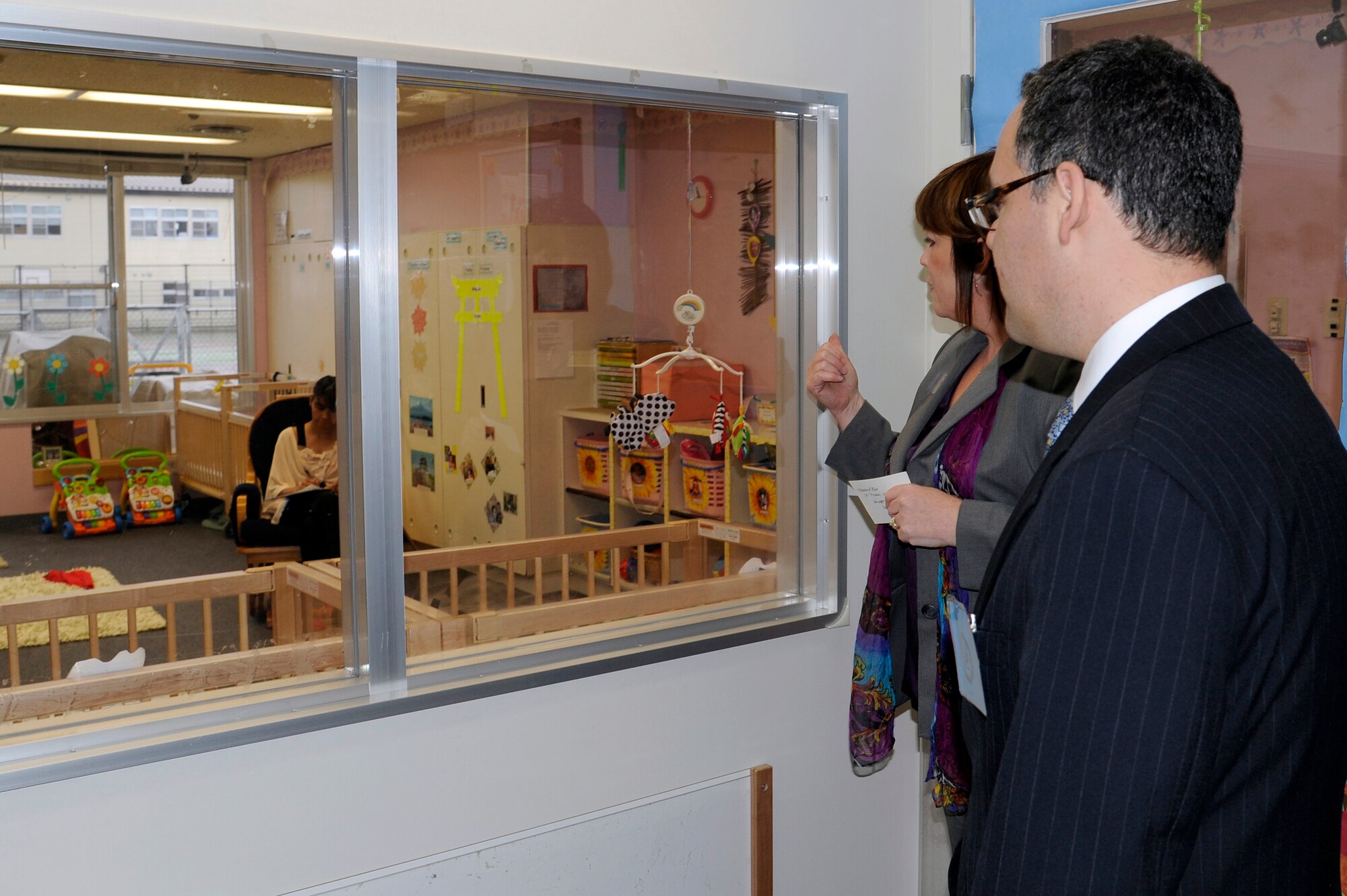 MISAWA AIR BASE, Japan - Daniel B. Ginsberg, Assistant Secretary of the Air Force for Manpower and Reserve Affairs, and Patricia Gurr, Yoiko Child Development Center director, look in on one of the infant rooms during his visit here Nov. 28. Ginsberg stopped at Misawa Air Base to visit base facilities and to thank the Misawa community for their efforts during Operation Tomodachi. (U.S. Air Force photo/Tech. Sgt. Marie Brown)