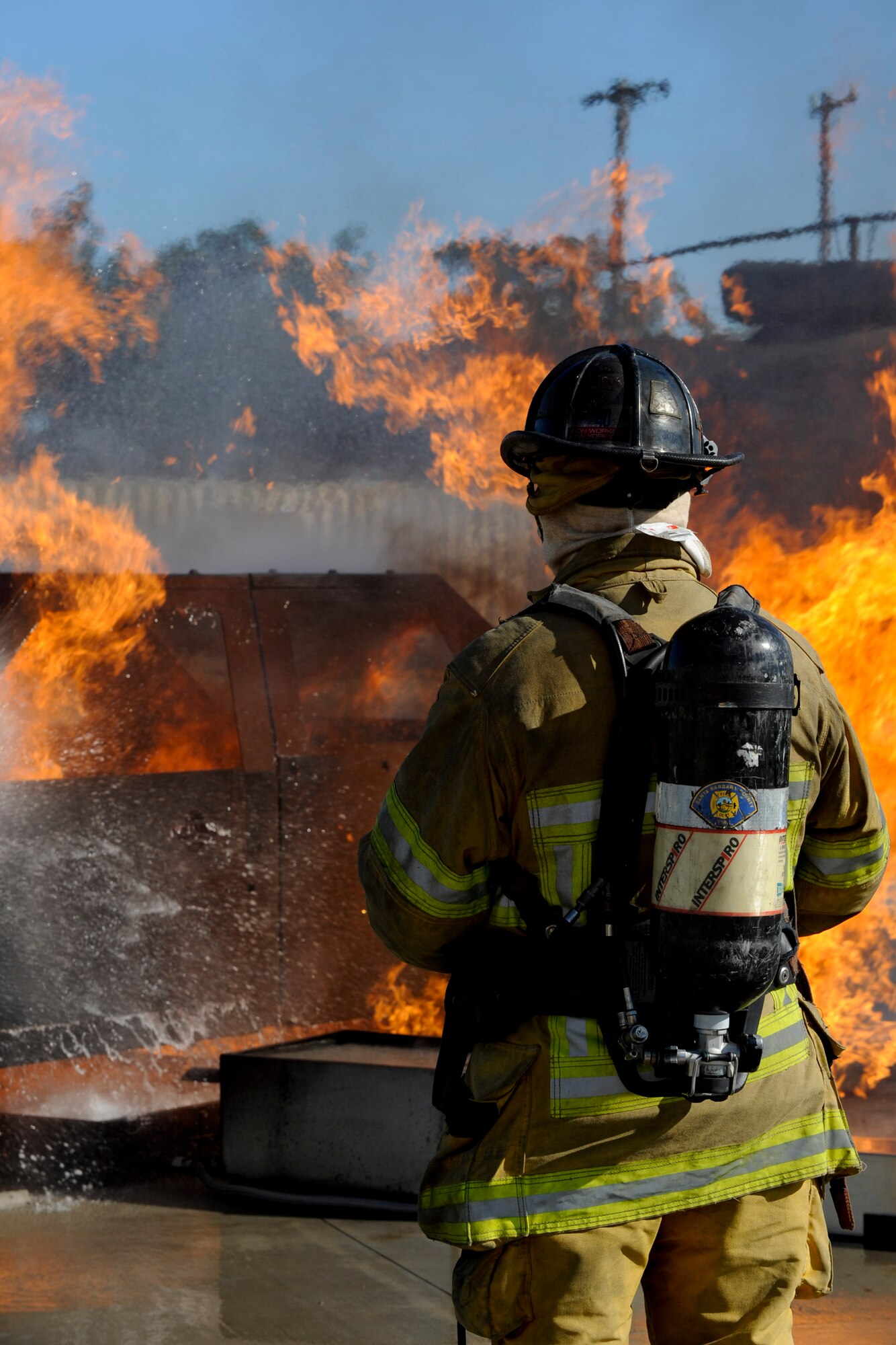 VANDENBERG AIR FORCE BASE, Calif. – An instructor firefighter from Allen Hancock College Fire Academy monitors students putting out a car fire during training at the Turner Bell Fire Training Campus here Wednesday, Nov. 30, 2011. Allen Hancock College students trained at Vandenberg to help build the required skills while their Public Safety Complex, which will incorporate skill training facilities, is under construction. (U.S. Air Force photo/Staff Sgt. Levi Riendeau)