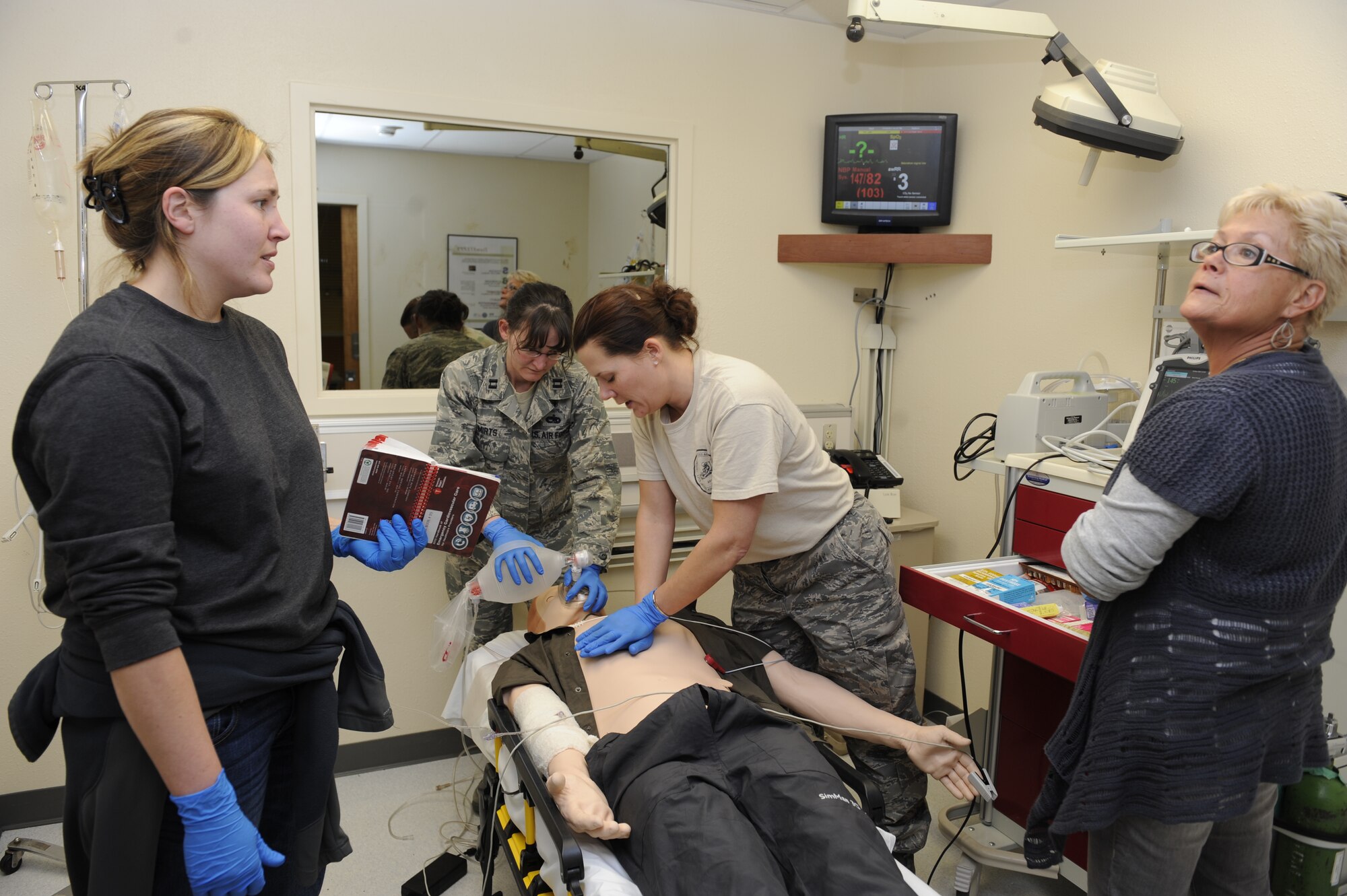 Medical students practice treating a "patient" suffering from ailments such as cardiac arrest during a training scenario simulating a medical emergency at the 673d Medical Group Simulation Center Nov. 10, 2011. The students come from a variety of medical departments to get the realistic practice. The "patient" is a high-tech manikin called SimMan equipped to simulate every sign and symptom a real patient would display. The training is performed with an instructor observing through a two-way mirror and recorded using action-by-action video and data collected using a Wi-Fi network. (U.S. Air Force photo/Staff Sgt. Robert Barnett)