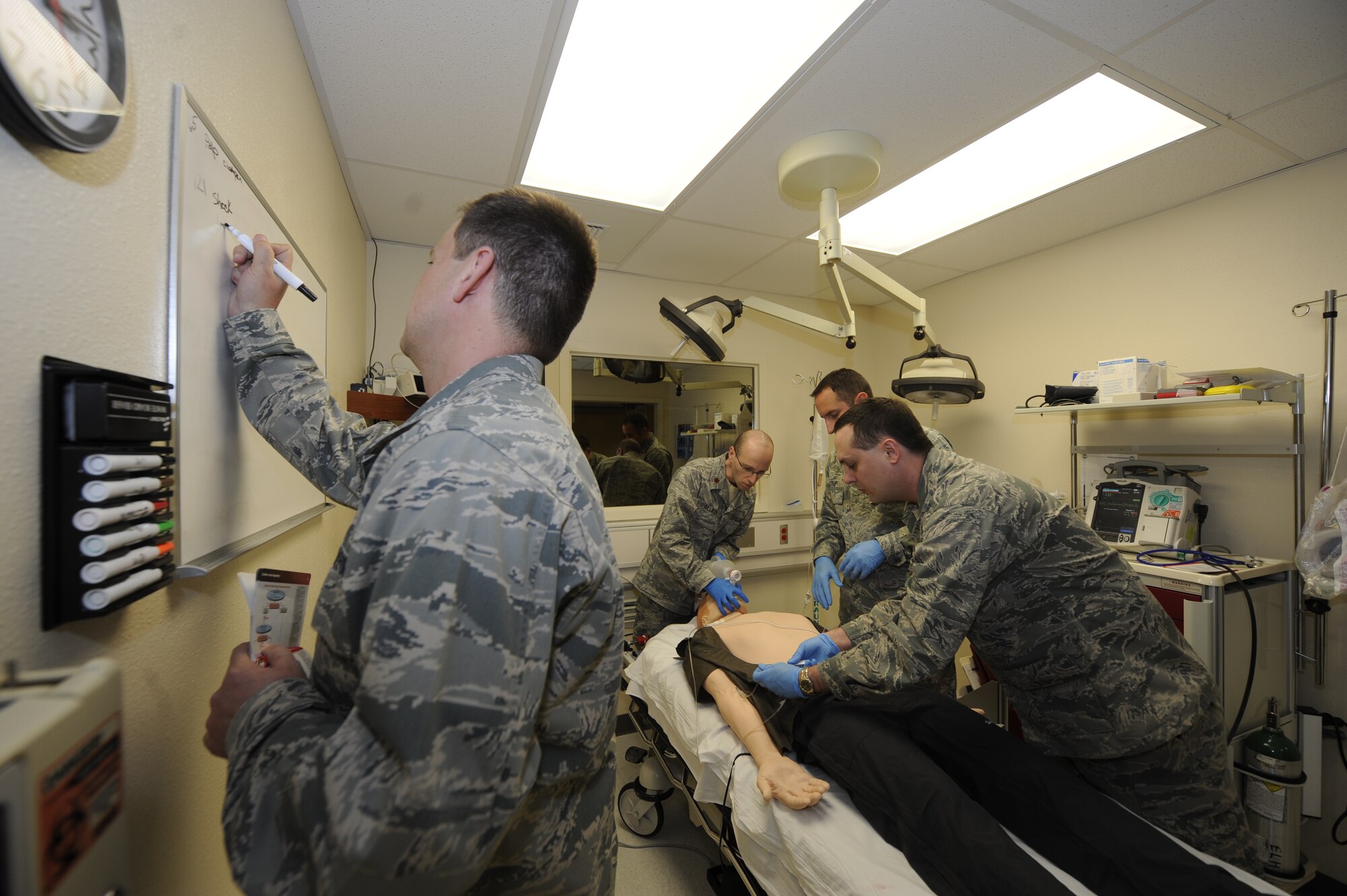 Medical students practice treating a "patient" suffering from ailments such as cardiac arrest during a training scenario simulating a medical emergency at the 673d Medical Group Simulation Center Nov. 10, 2011. The students come from a variety of medical departments to get the realistic practice. The "patient" is a high-tech manikin called SimMan equipped to simulate every sign and symptom a real patient would display. The training is performed with an instructor observing through a two-way mirror and recorded using action-by-action video and data collected using a Wi-Fi network. (U.S. Air Force photo/Staff Sgt. Robert Barnett)