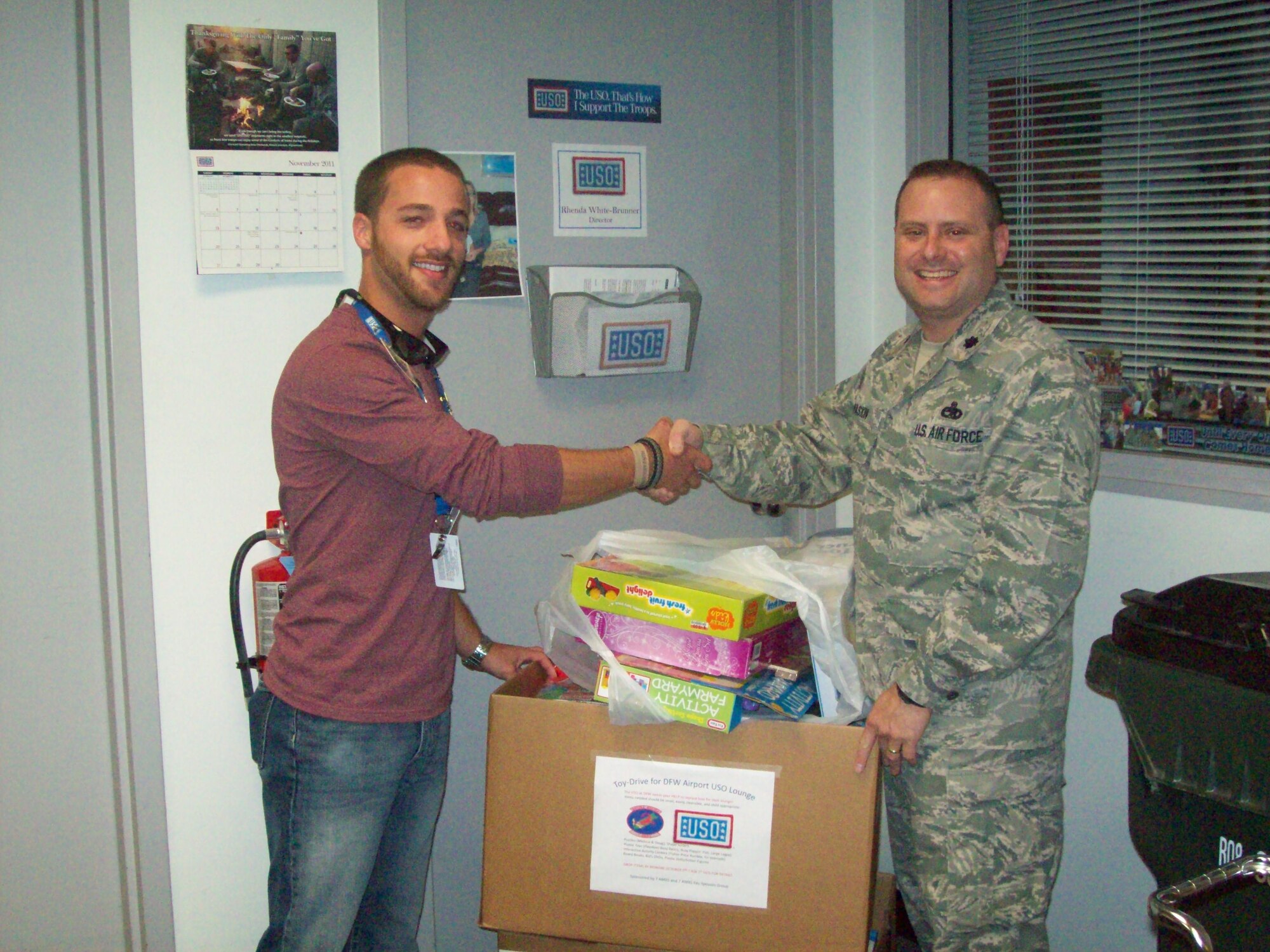 DALLAS, Texas—Lt. Col. Matthew Paskin, 7th Aircraft Maintenance Squadron commander, delivers more than 50 books, toys and puzzles to the Dallas Fort Worth Airport United Service Organizations Nov. 12, 2011 for children passing through for the upcoming holiday. The USO is a private, non-profit organization that provides morale and recreational services to military personnel and their families. To learn more about donating to the USO, logon to http://www.uso.org/donatelanding.aspx. (Courtesy photo)