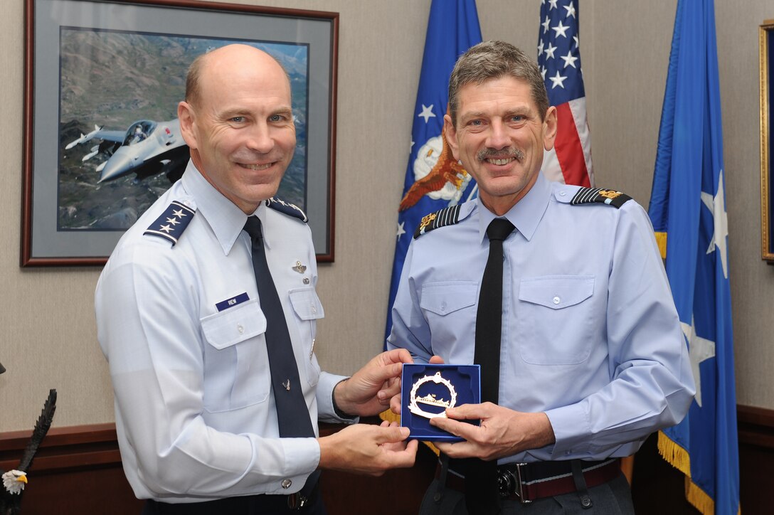 Lt. Gen. William Rew, Air Combat Command vice commander, presents a Heritage Park memento to British Air Chief Marshal Sir Simon Bryant, the Royal Air Force’s Air Command commander-in-chief, at Rew’s office at Langley Air Force Base, Va., Nov. 29, 2011. Bryant, who serves as the second-most senior officer in the RAF, visited several units at Langley, including the 94th Fighter Squadron and the 480th Intelligence, Surveillance and Reconnaissance Wing. (U.S. Air Force photo by Staff Sgt. Antoinette Gibson/Released)