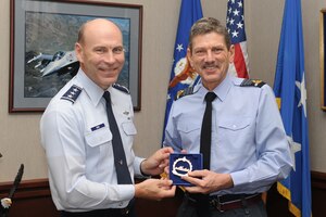 Lt. Gen. William Rew, Air Combat Command vice commander, presents a Heritage Park memento to British Air Chief Marshal Sir Simon Bryant, the Royal Air Force’s Air Command commander-in-chief, at Rew’s office at Langley Air Force Base, Va., Nov. 29, 2011. Bryant, who serves as the second-most senior officer in the RAF, visited several units at Langley, including the 94th Fighter Squadron and the 480th Intelligence, Surveillance and Reconnaissance Wing. (U.S. Air Force photo by Staff Sgt. Antoinette Gibson/Released)