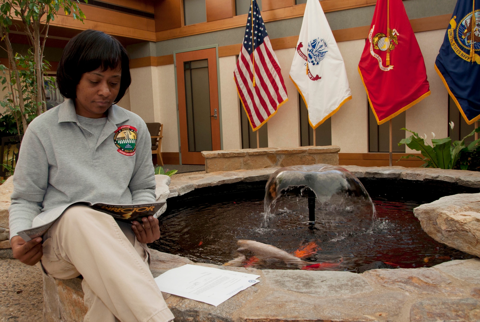 Mable Justice, an embalmer with Air Force Mortuary Affairs Operations, takes a moment to read a magazine in the atrium by the koi pond in the Charles C. Carson Center for Mortuary Affairs, Dover Air Force Base, Del., Nov. 30, 2011. The mortuary specialist earned a degree in Mortuary science in 2007 from Catonsville Community College of Baltimore County. (U.S. Air Force photo/Tech. Sgt. Marvin B. Moore)