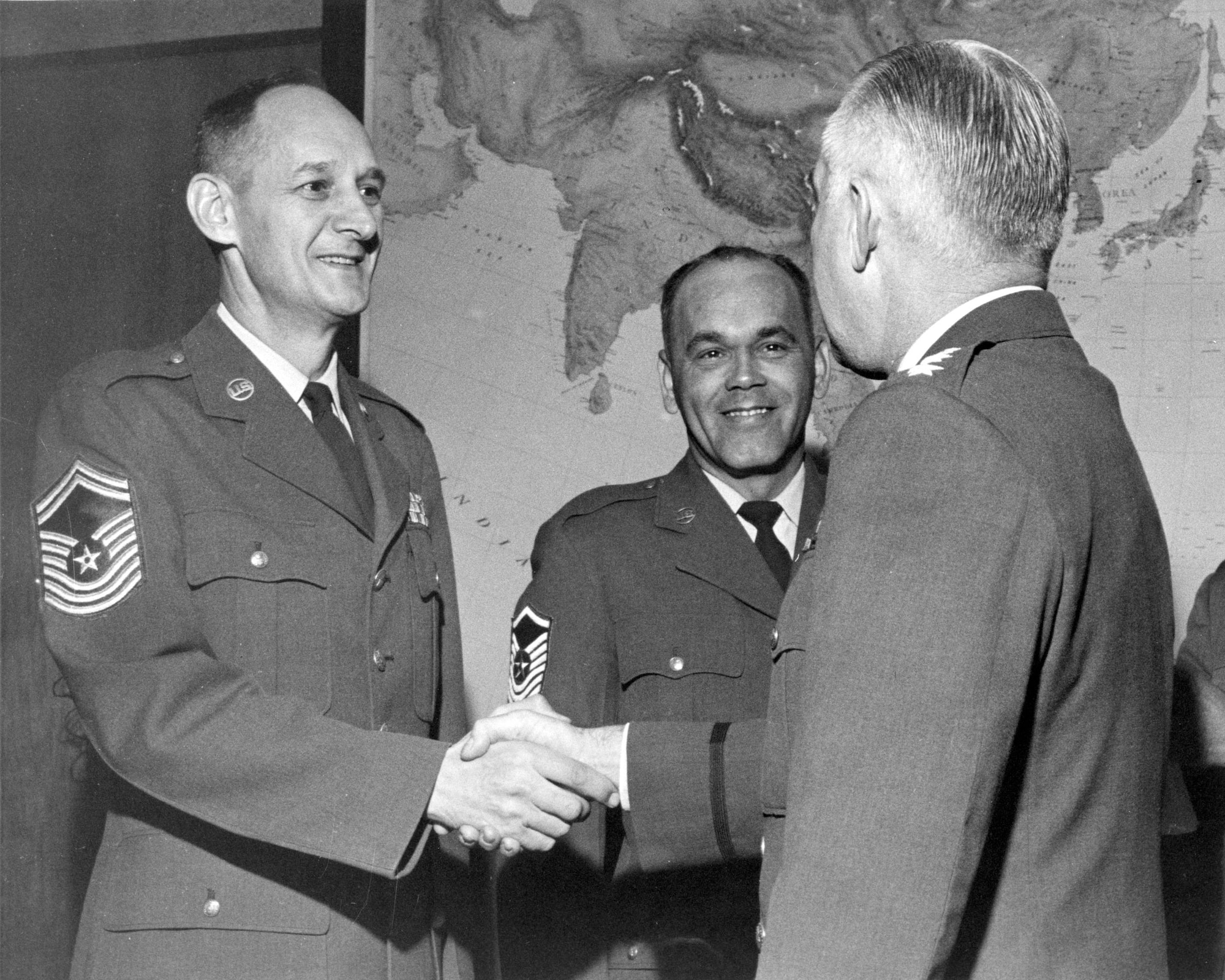 Chief Master Sgt. Francis Collier (left) receives a handshake from Lt. Gen. Robert W. Burns, the 5th Air Force commander, upon his promotion to the “new grade” of chief master sergeant Dec. 1, 1959. Collier was one of 625 Airmen promoted to the new super grade of chief master sergeant as a result of the Career Compensation Act of 1958. (Courtesy photo)