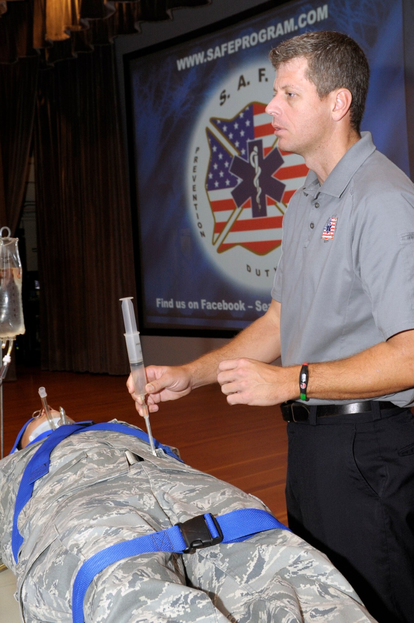 VANDENBERG AIR FORCE BASE, Calif. -- Jeremy Cadorette, an Orlando, Fla., firefighter, demonstrates to the audience how trauma center doctors would use a large bore needle to determine internal bleeding in an accident victim during a safety presentation here Wednesday, Nov. 30, 2011. The Street Smart presentation is part of a national program created by Florida Stay Alive From Education in 1988 to help reduce the occurrence of drinking and driving. 
 (U.S. Air Force photo/Jerry E. Clemens, Jr.)
