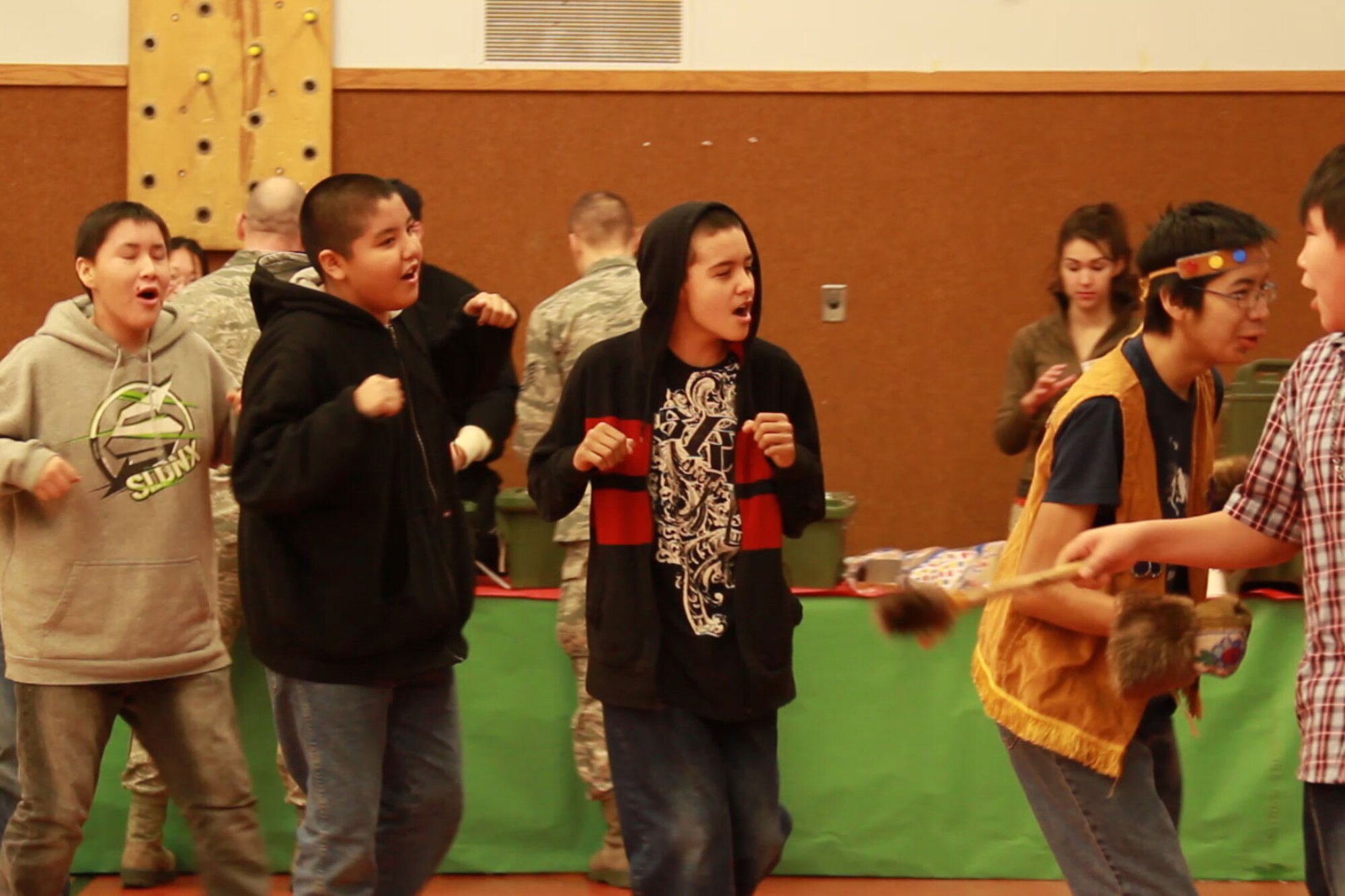 The Allakaket youth performing a native dance for the guests and volunteers before the festivities. The village of around 185 residents welcomed the volunteers into their school for the day to celebrate Christmas.. (Alaska National Guard photo\Lt. Bernie Kale),

