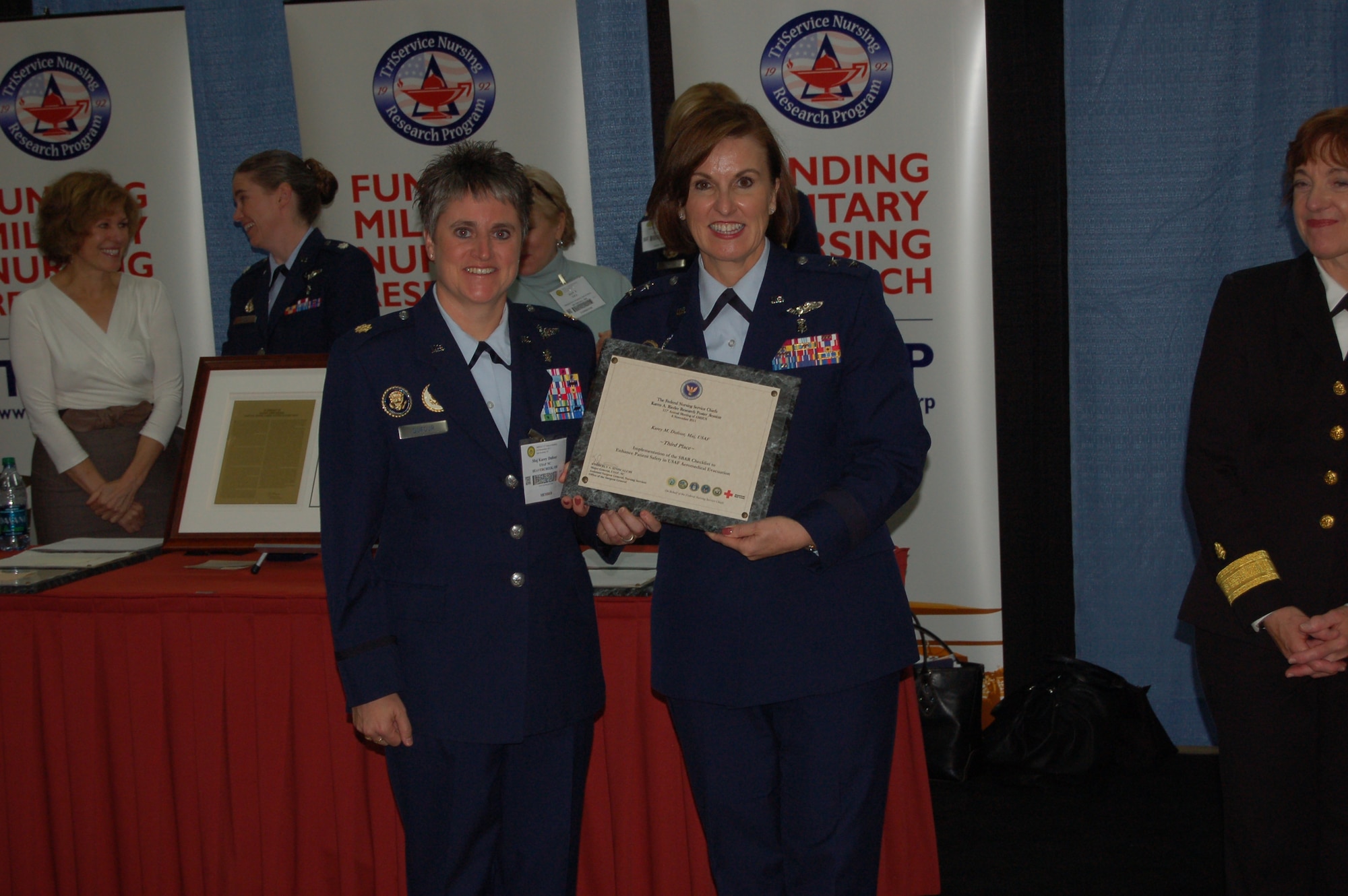 At the 117th annual Association of Military Surgeons United States Conference held in San Antonio, Texas, on 6-9 Nov, Maj. Gen. Kimberly Siniscalchi, Assistant Surgeon General, Nursing Services and Medical Force Development, presents Maj. Karey Dufour the third place award for her abstract submission of Aeromedical evacuation Situation Assessment Background Recommendation (SABR) Tool, currently receiving a trial implementation in USAF AE.  Maj. Dufour is one of the new nurses in the Flight Nurse Clinical Nurse Specialists program.  (USAF Courtesy Photo)