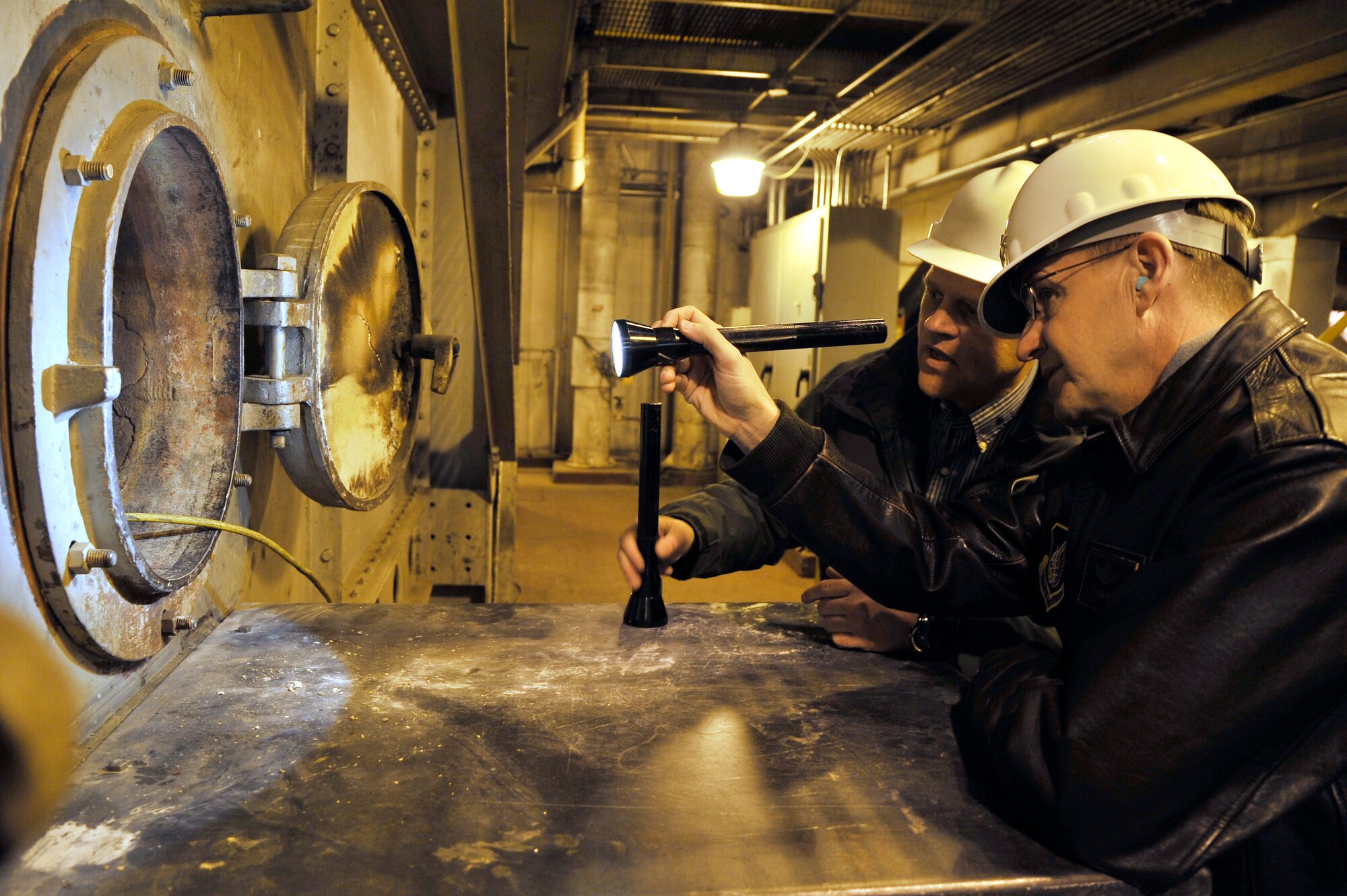 U.S. Air Force Lt. Gen. Stephen Hoog looks at a boiler furnace and receives information from Marty Overlin on how it functions and operates at the central heat and power plant Nov. 21, 2011, Eielson Air Force Base, Alaska. Overlin is the superintendent at the CHPP and Hoog is the Alaskan Command and 11th Air Force commander. (U.S. Air Force photo by Staff Sgt. Christopher Boitz)