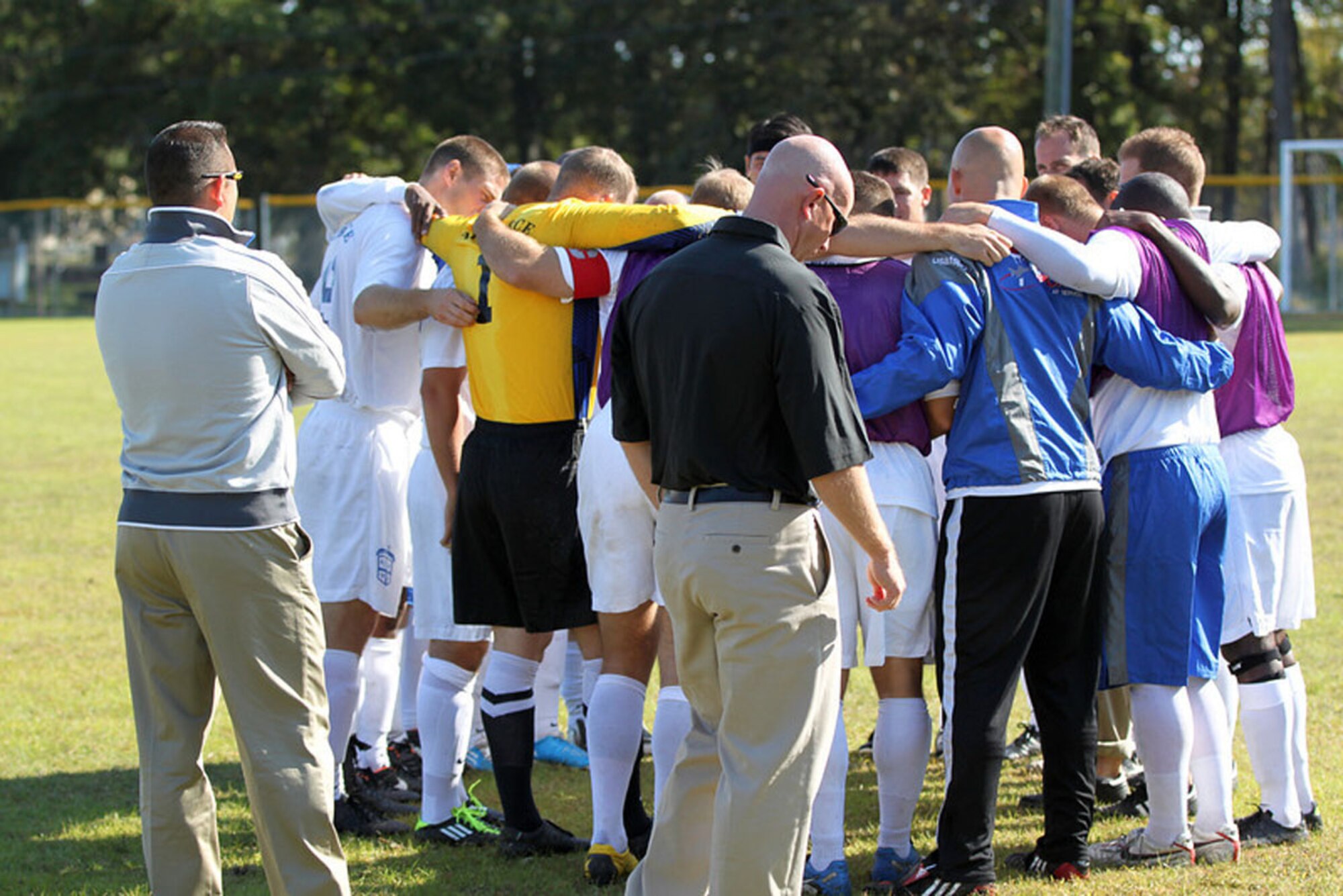 LANGLEY AIR FORCE BASE, Va. – Maj. Derrick Weyand (center), 66th Security Forces Squadron commander and head coach of the Air Force men’s soccer team, and Master Sgt. Raul Martinez (left), Electronic Systems Center commander’s enlisted aide and assistant coach of the Air Force men’s soccer team, wait while their team gets pumped up for the championship game against Navy. Air Force placed first in the 2011 Armed Forces Soccer Championship held Oct. 19 through 24. (Courtesy photo)
