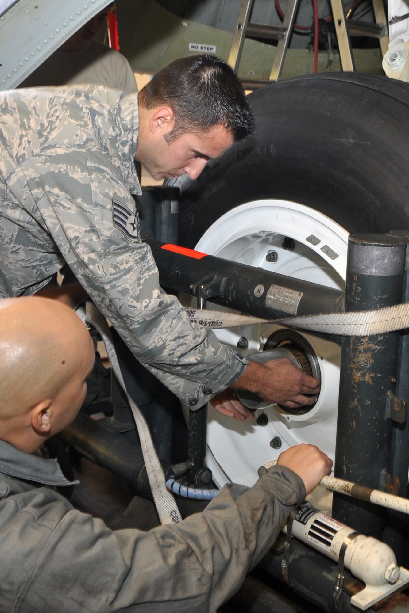 With the help of Airman 1st Class Anthony Del Rio, Staff Sgt. Byron Landon, who is a repair and reclamation technician, pulls a main landing gear wheel bearing in preparation of removing a wheel on a B-52 Stratofortress for a brake inspection at the phase hangar at Barksdale Air Force Base, La., Nov. 9, 2011. Landon, who is a Reservist assigned to the 707th Maintenance Squadron and Del Rio, who is an Active Duty Airman assigned to the 2nd Maintenance Squadron, work side by side as part of the Total Force Enterprise, which combines both Active Duty and Reserve components working together on the same aircraft.  (U.S. Air Force photo by Master Sgt. Jeff Walston)

