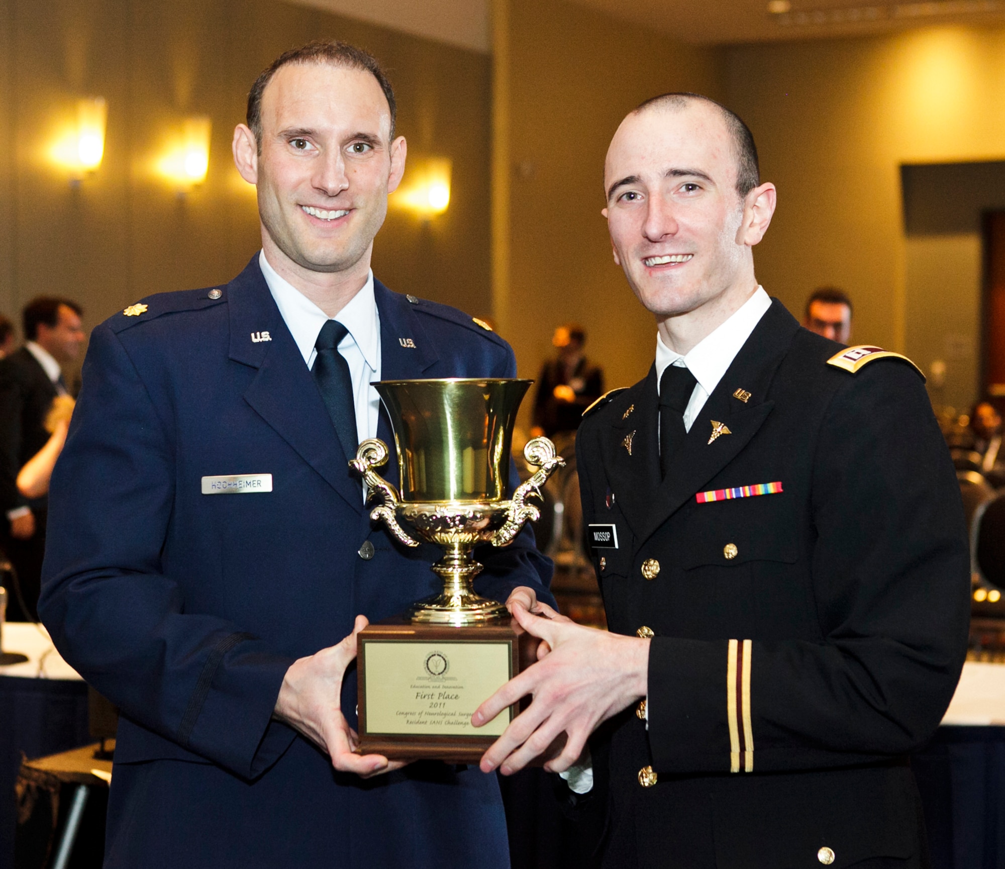 Air Force Maj. Sven Hochheimer (left) and Army Capt. Corey Mossop hold their first place trophy after winning the Congress of Neurological Surgeons Challenge Oct. 4, 2011, in Washington, D.C. The competition tested neurosurgery residents from across the country on their knowledge in a game show-style event. Both doctors are assigned to the National Capital Consortium Neurosurgery Program, Walter Reed National Military Medical Center, Bethesda, Md. (Courtesy photo)