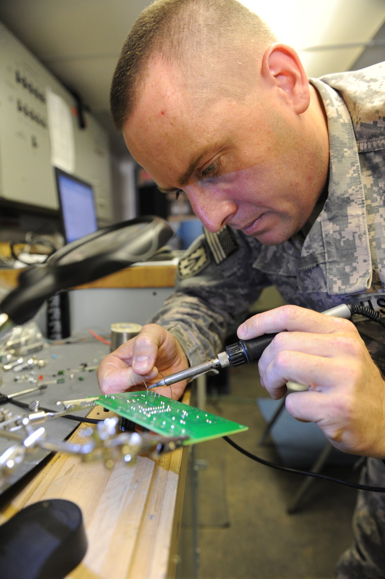 Army Staff Sgt. Jeremy Hedlind solders a component onto a printed circuit board while repairing a television set, Oct. 4, 2011. Hedlind and his group of electronics specialists have started a volunteer shop to repair personal electronics for the deployed Airmen, Soldiers and Sailors at the 380th Air Expeditionary Wing, lending their time and talents to help other service members, while gaining valuable experience and honing their skills. Hedlind is the missile maintenance NCO for the intermediate support element of the 3rd Battalion, 4th Air Defense Artillery Regiment and is deployed from Fort Bragg, N.C. He hails from Eugene, Ore. (U.S. Air Force photo/Master Sgt. Chance Babin) 
