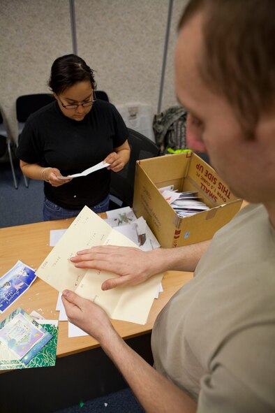 Airman 1st Class John Loiselle, 51st Logistics Readiness Squadron, runs his hand across the Braille on a holiday card written to a Wounded Warrior Nov. 22 during the 5th annual Holiday Mail for Heroes program. The program, facilitated by the American Red Cross, was developed so military members can receive holiday greetings from back home. (U.S. Air Force photo/Staff Sgt. Rick Maricle)