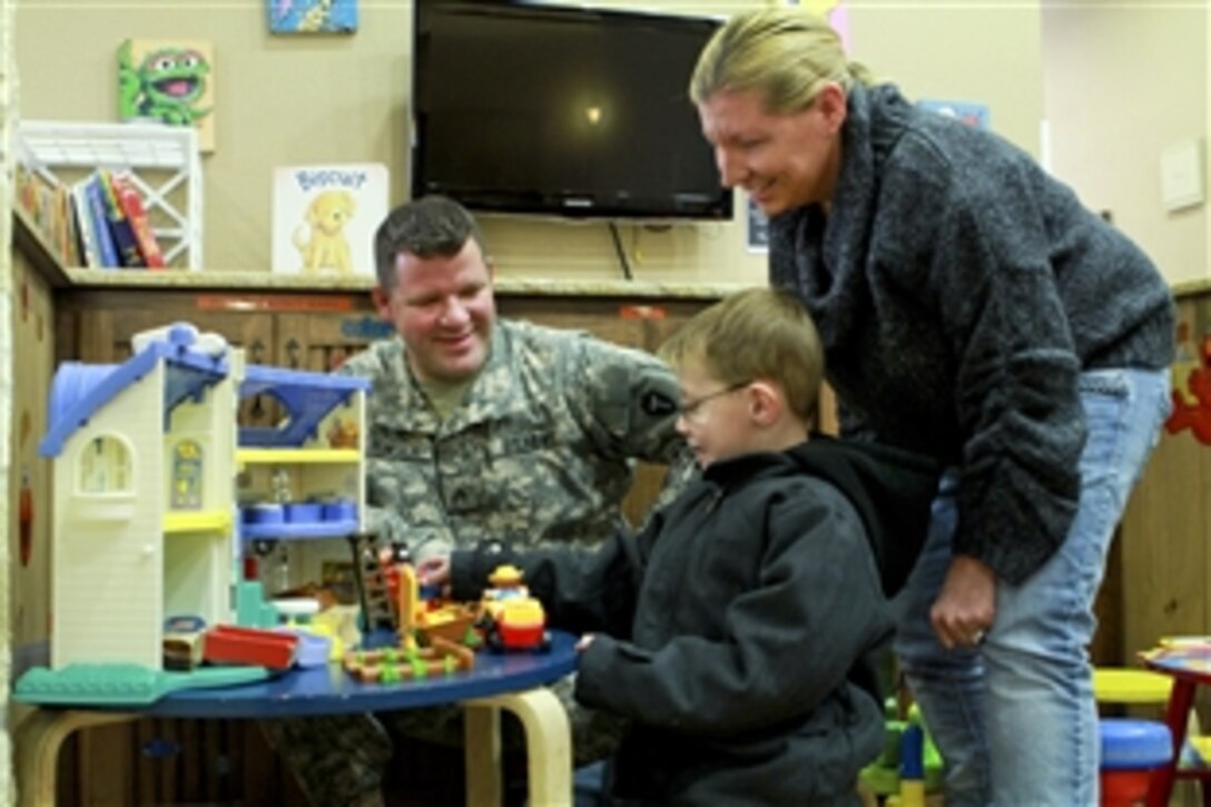 Army Sgt. John Tomsich and his wife, Catrina, play with their son, Brayden, in a play area at the Warrior and Family Support Center in San Antonio, Nov. 10, 2011. Tomsich came to Brooke Army Medical Center for treatment for a spinal injury. Catrina Tomsich put her business on hold to join him and urged him to get tested for post-traumatic stress disorder. Doctors confirmed the diagnosis and she has remained with him on Fort Sam Houston as his caregiver.