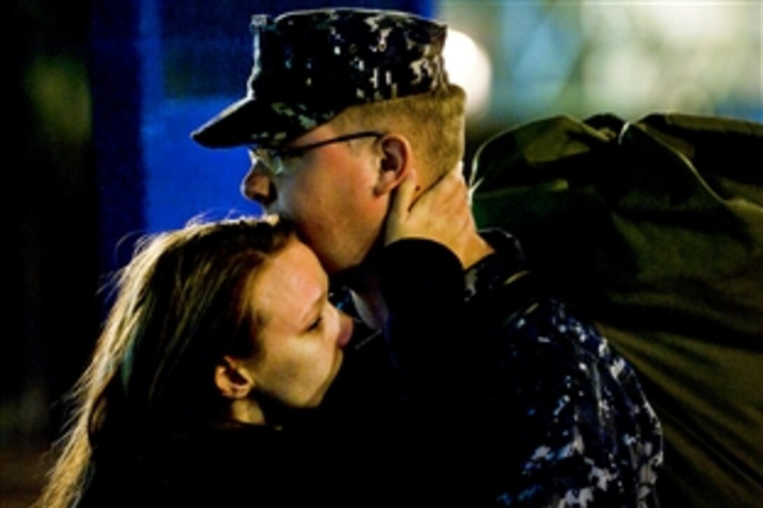 A sailor embraces a family member before the aircraft carrier USS Carl Vinson departs Naval Air Station North Island in Coronado, Calif., Nov. 30, 2011, for deployment to a western Pacific region.