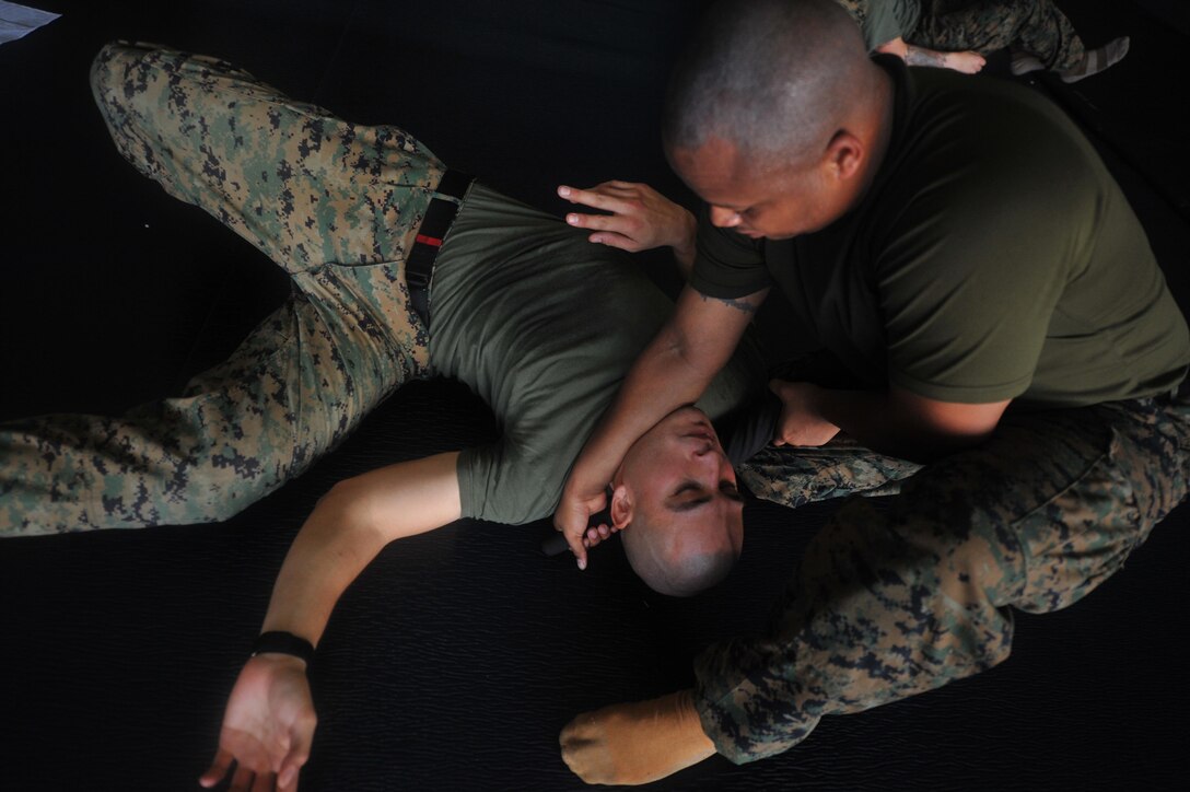 Staff Sgt. Christian L. Dueberry chokes Sgt. Miguel O. Bravo with a baton while practicing Marine Corps aboard USS Makin Island here Nov. 30. The Marines serve with the 11th Marine Expeditionary UnitÕs command element. The unit embarked USS Makin Island, USS New Orleans and USS Pearl Harbor in San Diego Nov. 14 to begin a seven-month deployment to the Western Pacific and Middle East regions.