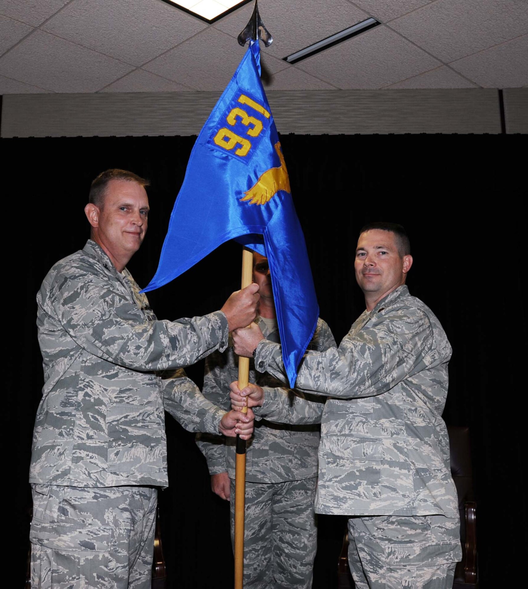 Col. William H. Mason, commander, 931st Air Refueling Group, presents the 931st Security Forces Squadron guidon to Maj. Edward T. Hunn during an assumption of command ceremony at McConnell Air Force Base, Kan., Oct. 1.  Hunn became the new squadron's first commander during the ceremony, which was held immediately following the squadron's activation.  (U.S. Air Force photo by 1st Lt. Zach Anderson)