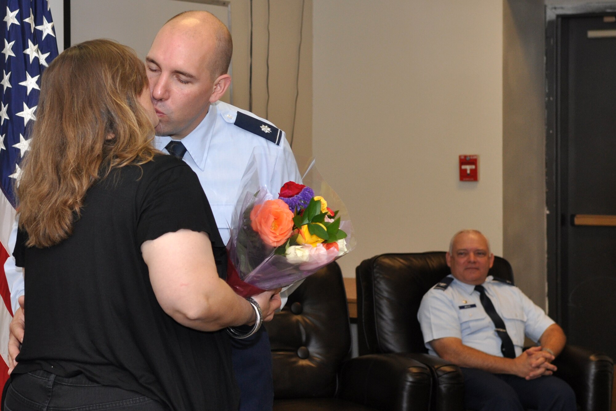 Lt. Col. Charles B. Chapman III, the commander of the 307th Civil Engineer Squadron presents his wife Heidi with a bouquet of flowers and a kiss during a promotion ceremony at Barksdale Air Force Base, La., Oct. 1, 2011. The presiding official for the ceremony was Col. Kevin Wolfe, the 307th Mission Support Group commander. (U.S. Air Force photo by Master Sgt. Jeff Walston/Released)