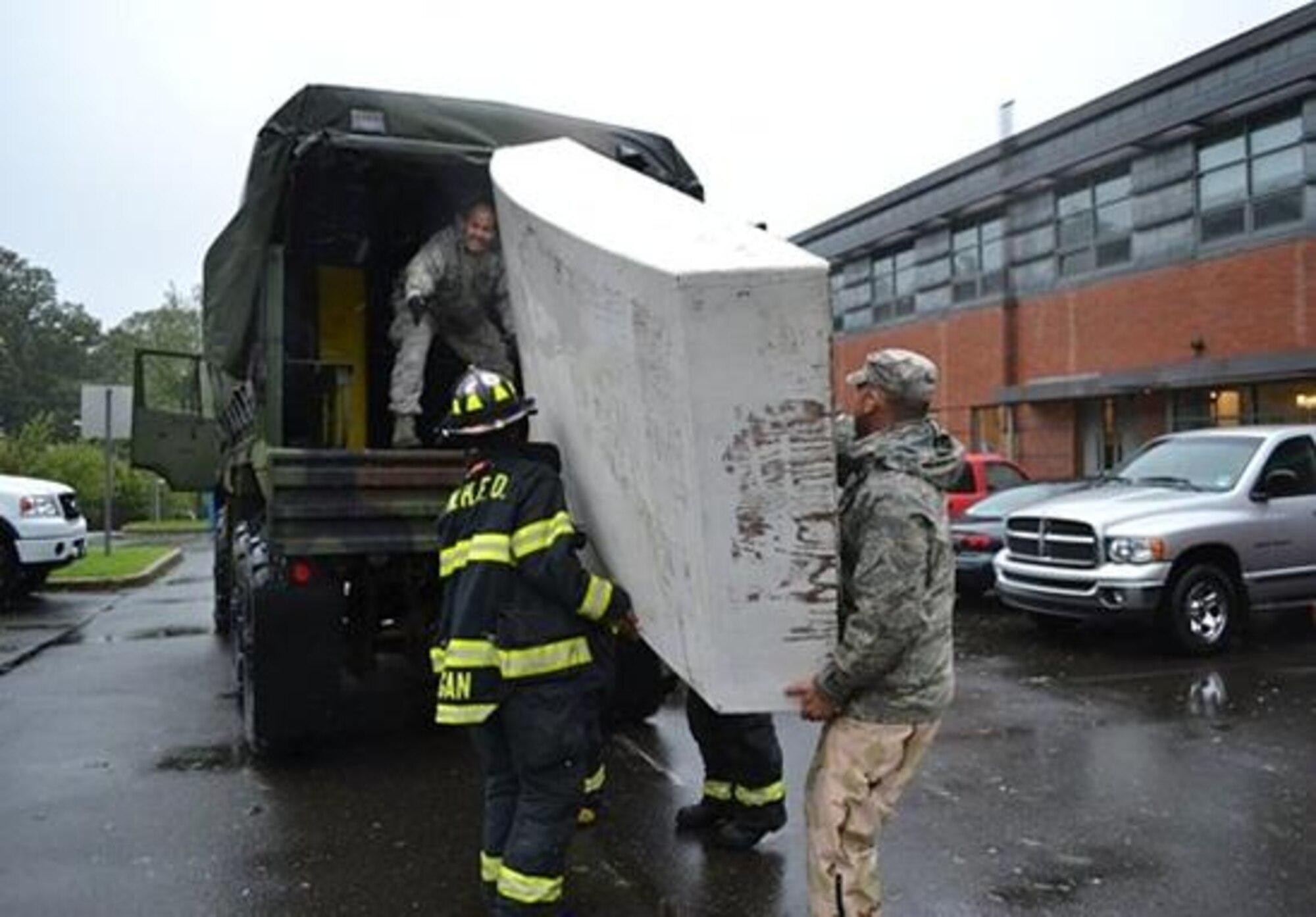 Tech. Sgt. Luis Hilerio and Tech. Sgt. William Stanton from the 103rd Air Control Squadron, Connecticut Air National Guard, load a small fire-rescue boat into the back of military vehicle with a local firefighter during hurricane Irene relief operations in August 2011. These boats were used to rescue families from the Fair Haven, Conn. community. (Photo courtesy of 103rd ACS UPAR)