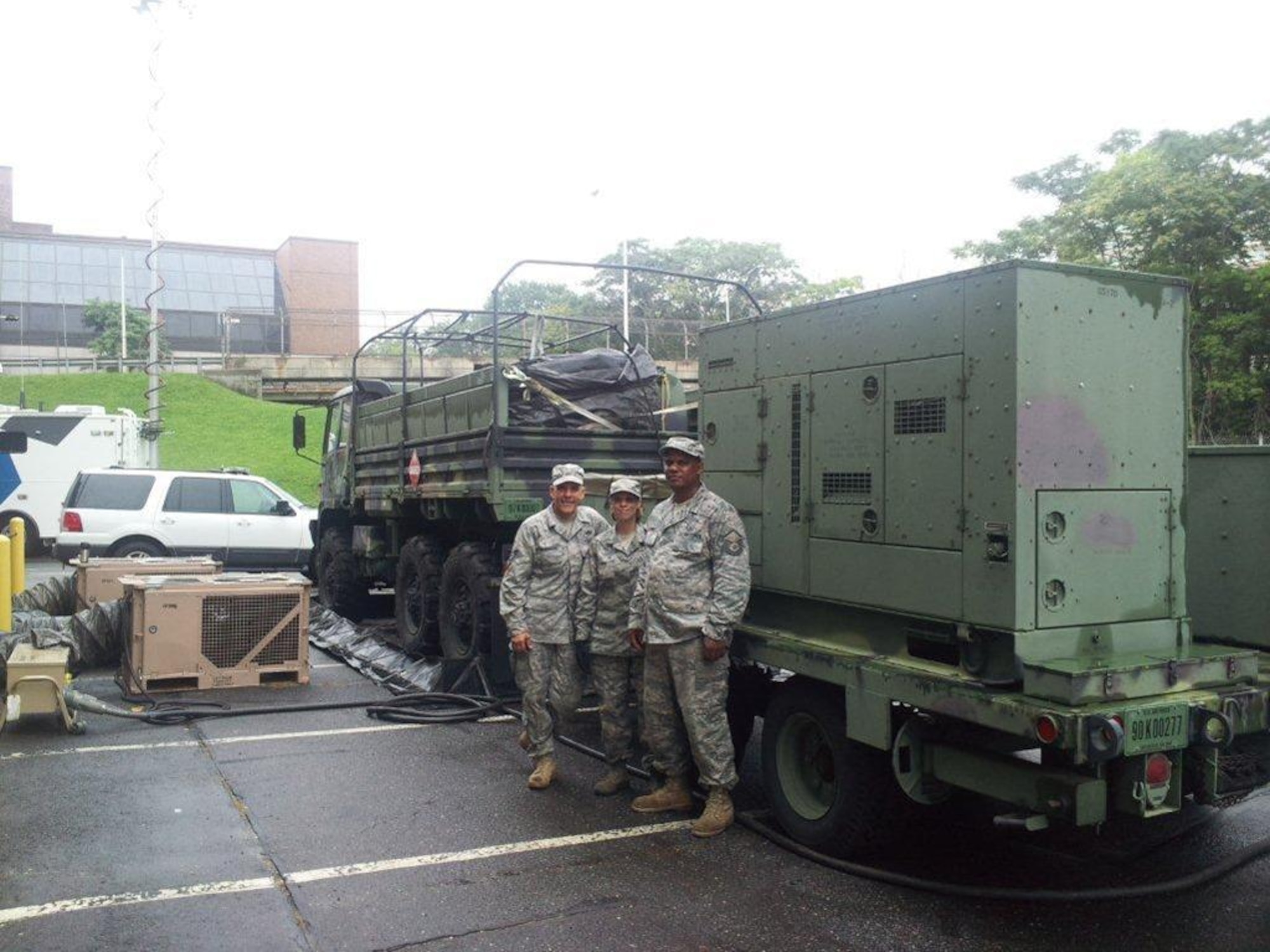 Connecticut Air National Guardsmen Tech. Sgt. John Anderson, Tech. Sgt. Rachel Payne and Master Sgt. Andre Jaynes stand with air conditioning units that were transported and set up at the Hartford Armory during storm-relief efforts is the wake of hurricane Irene August 2011. (Photo courtesy of 103rd ACS UPAR)