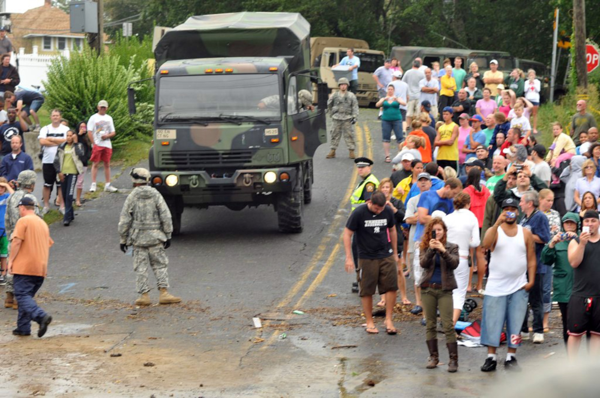 Members of the 192nd Multi-Functional Engineer Battalion, Connecticut Army National Guard guide a vehicle through the crowd looking at flooding along the shore in the aftermath of Hurricane/Tropical Storm Irene on Aug. 28, 2011. The engineers were among many Connecticut Guardsmen called out to assist local authorities before, during and after the storm battered the coastline. (U.S. Army photo by Capt. Chuck Taylor) 